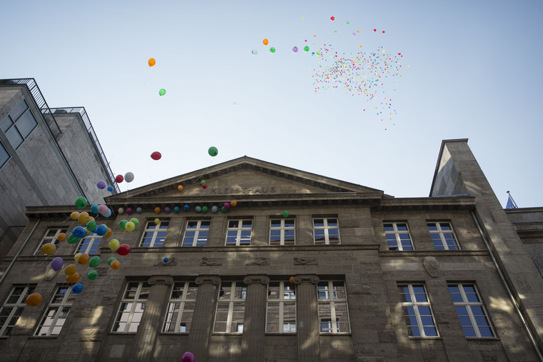 Das Kleisthaus mit Blick nach oben fotografiert. Bunte Luftballons fliegen vor der Fassade nach oben.